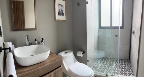 y baño con lavabo blanco y ducha. en Amplio y moderno departamento en la Condesa en Ciudad de México