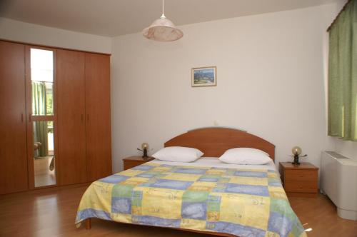 ein Schlafzimmer mit einem Bett mit einer bunten Decke in der Unterkunft Apartments by the sea Primosten - 9687 in Primošten