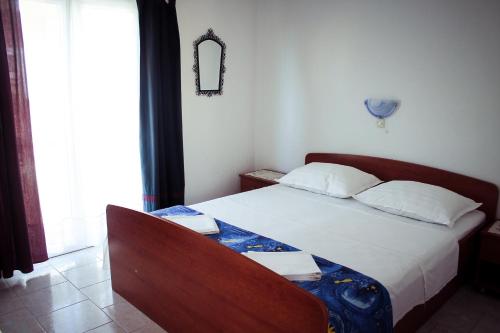 a bedroom with a bed and a chair and a window at Apartments and rooms by the sea Podgora, Makarska - 11894 in Podgora