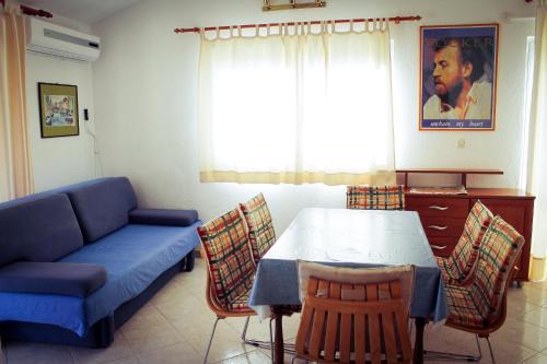 a living room with a couch and a table and chairs at Apartments and rooms by the sea Podgora, Makarska - 11894 in Podgora
