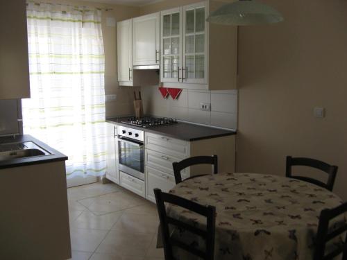 a kitchen with a table and a kitchen with a stove at Holiday house with WiFi Susak, Losinj - 11911 in Susak