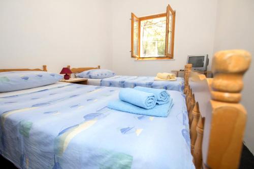 1 Schlafzimmer mit 2 Betten, Handtüchern und einem Spiegel in der Unterkunft Apartments by the sea Zuronja, Peljesac - 12020 in Putniković