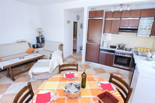 Apartments by the sea Zuronja, Peljesac - 12020 في Putniković: مطبخ وغرفة معيشة مع طاولة وكراسي