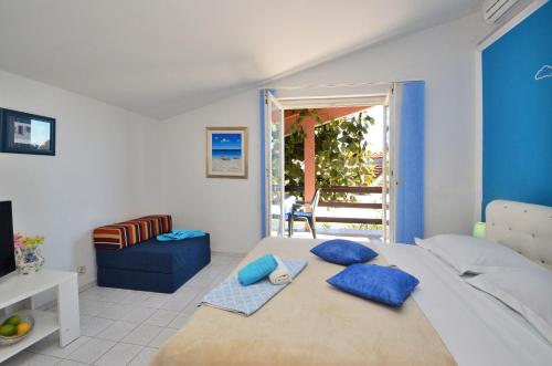 a bedroom with a large bed with blue pillows at Apartments with a parking space Orebic, Peljesac - 12041 in Orebić