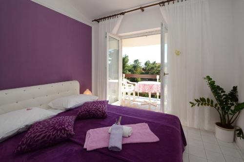 um quarto com uma cama roxa com toalhas em Apartment Orebic 12041c em Orebić