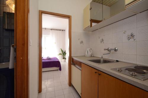uma cozinha com um lavatório e uma bancada em Apartment Orebic 12041c em Orebić