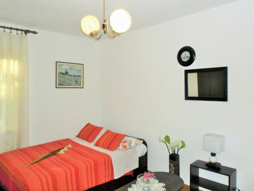 a white bedroom with a bed and a tv at Holiday house with a parking space Sumartin, Brac - 12047 in Sumartin