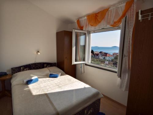 a small bedroom with a bed and a window at Apartments by the sea Prvic Luka, Prvic - 12064 in Prvić Luka