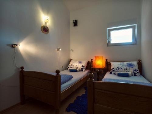 a bedroom with two beds and a lamp in it at Apartments by the sea Prvic Luka, Prvic - 12064 in Prvić Luka