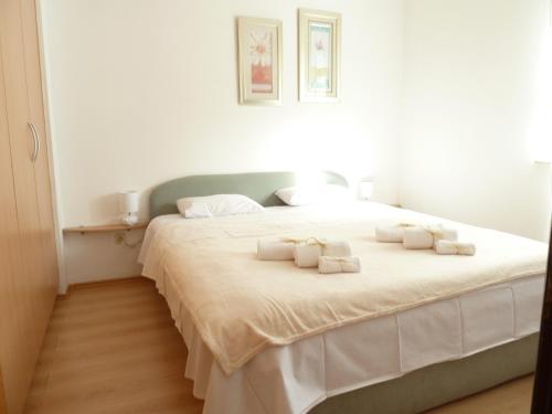 a bedroom with a large white bed with towels on it at Apartments with a parking space Murter - 12067 in Murter