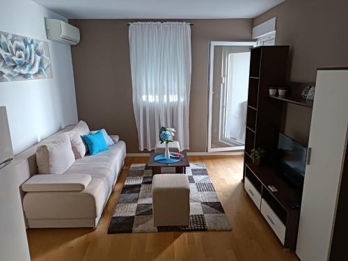 a living room with a white couch and a tv at Apartments with WiFi Split - 12072 in Split