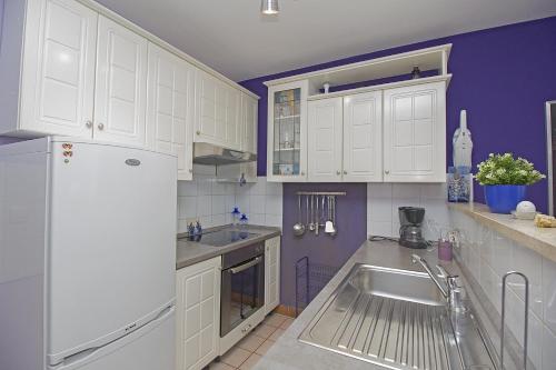 una cucina con mobili bianchi, un lavello e un frigorifero di Apartments with a parking space Rabac, Labin - 12100 a Rabac