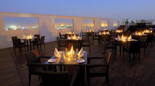a restaurant with tables and chairs with lights on them at Hotel Marigold Jaipur in Jaipur