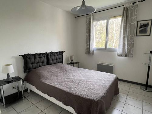 Un dormitorio con una cama grande y una ventana en Appartement Cambo-les-Bains, 2 pièces, 3 personnes - FR-1-495-109, en Cambo-les-Bains