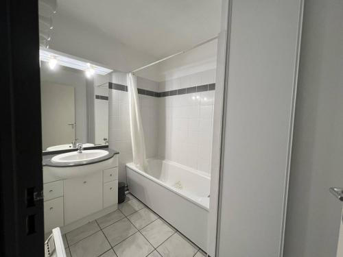 une salle de bain avec une baignoire et un lavabo et une baignoire dans l'établissement Appartement T2 calme avec terrasse et parking à Cambo-les-Bains, proche centre et thermes - FR-1-495-109, à Cambo-les-Bains