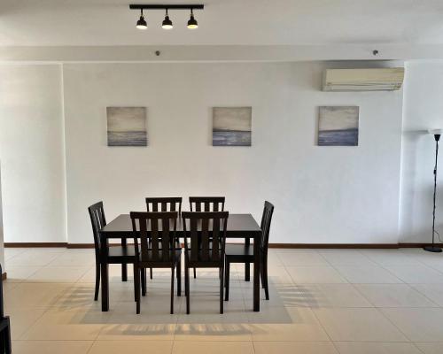 a dining room with a black table and chairs at The Landmark Comfort Relax Spacious Sea View By IZ in Tanjong Tokong