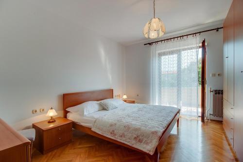 a bedroom with a bed and a large window at Apartments with a parking space Nerezine, Losinj - 12149 in Nerezine