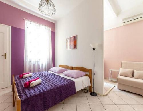 sypialnia z łóżkiem z fioletową pościelą i kanapą w obiekcie Apartments with WiFi Split - 12154 w Splicie