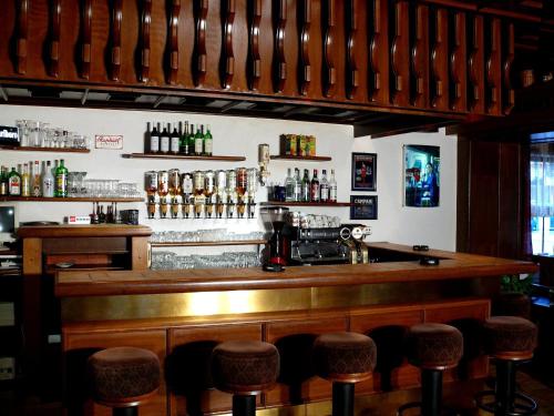 a bar with a row of stools in a room at Pension Faema in Harrachov