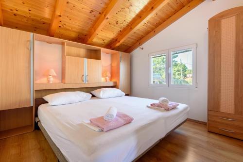 1 dormitorio con 1 cama blanca grande y toallas. en Apartments by the sea Basina, Hvar - 11817 en Vrbanj