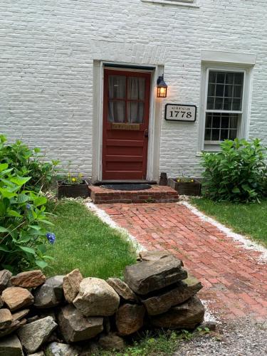a house with a red door and a stone wall at Innkeeper's Place B&B in Stafford Springs