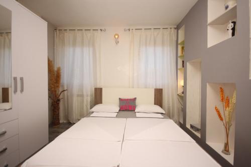 a large white bedroom with two beds in it at Apartments for families with children Sisan, Medulin - 12199 in Ližnjan