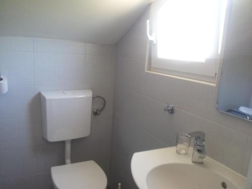 een badkamer met toilet, wastafel en raam bij Apartments with a parking space Vodice - 12206 in Vodice