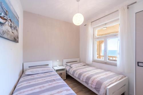 two beds in a room with a window at Apartments by the sea Cove Zaglav, Korcula - 12208 in Prizba