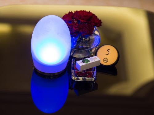 a blue lamp with flowers and a vase of flowers at Kasion International Hotel Yiwu in Yiwu