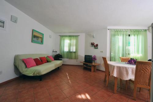 ein Wohnzimmer mit Sofa und Tisch in der Unterkunft Seaside house for families with children Zatoglav, Rogoznica - 12212 in Rogoznica