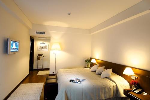 a hotel room with a large bed and two lamps at Ontur Izmir Otel in Izmir