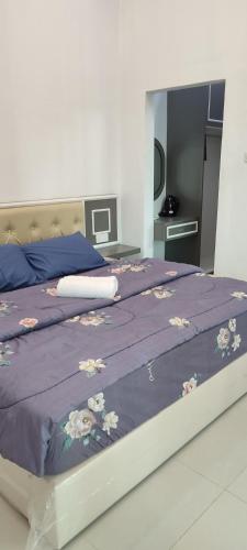 a bedroom with a purple bed with flowers on it at Captain's Cabin Resort - Naval Heritage (Swimming Pool) in Kota Bharu