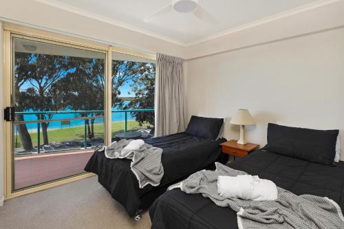 uma sala de estar com uma cama e uma janela em PICNIC7- PICTURE PERFECT PICNIC POINT em Maroochydore