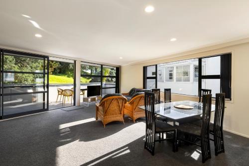 sala de estar con mesa, sillas y sofá en Pacific Escape - Downtown, Beach & Sea Views, en Mount Maunganui