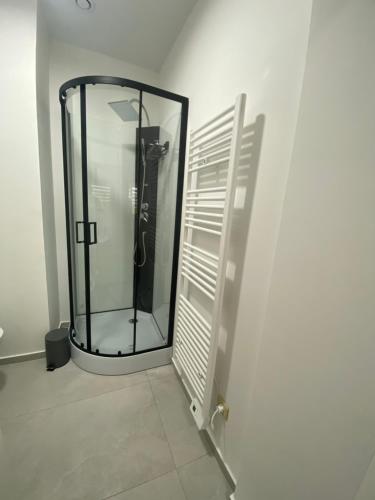 uma casa de banho com um chuveiro e uma porta de vidro em 010-Superbe appartement bien décoré netflix gratuit em Charleroi