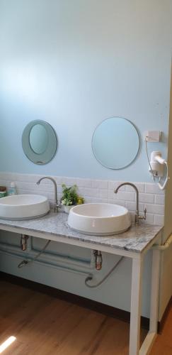 two sinks in a bathroom with two mirrors at Nature Village Hostel in Lak Si