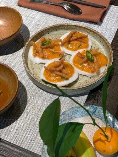 a plate of food with eggs on a table at Kaia Gallery Hotel Hoi An in Hoi An