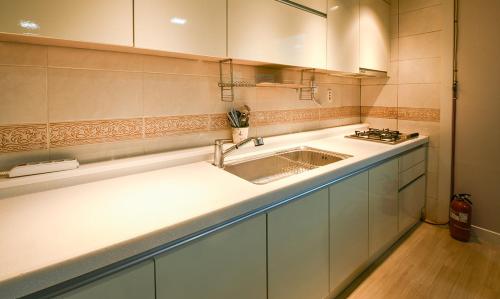 a kitchen with a sink and a counter top at Yeonhwachon Pension in Jeju