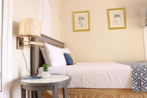 a bedroom with a bed and a table with a lamp at Northside Studio Vacation Rental in St Thomas