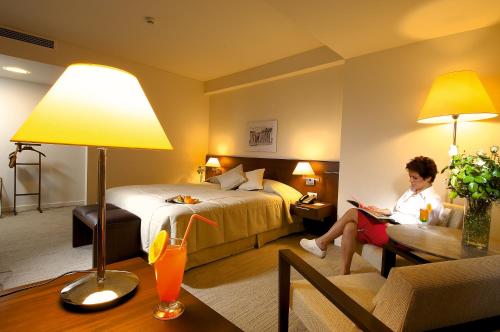 a woman is sitting in a hotel room at Ontur Izmir Otel in Izmir