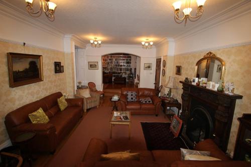 a living room with couches and a fireplace at Woodlands Bed & Breakfast in Barnt Green