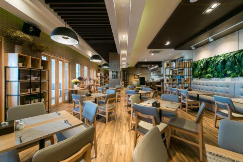 a restaurant with wooden tables and blue chairs at Nadee 10 Resort & Hotel in Khon Kaen