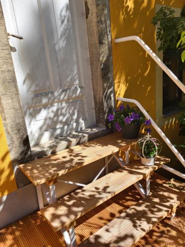 a wooden bench on a porch with flowers on it at Im Herzen des Elbsandsteingebirges in Königstein an der Elbe