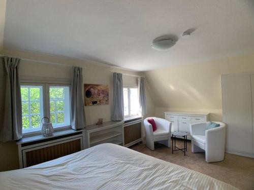 une chambre avec un lit, un bureau et des chaises dans l'établissement Top Lage! Charmantes Landhaus 5 Geh-Min v. Strand, à Timmendorfer Strand