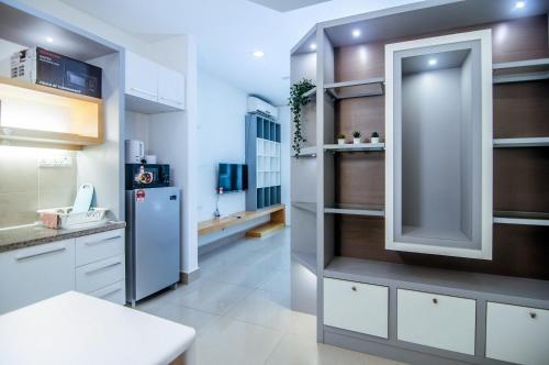 a kitchen with white cabinets and a refrigerator at Shaftsbury Cyberjaya by IdealHub in Cyberjaya