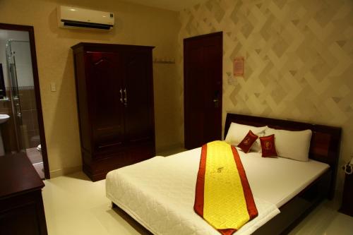 a bedroom with a bed with white sheets and red pillows at Minh Kieu Hotel in My Tho