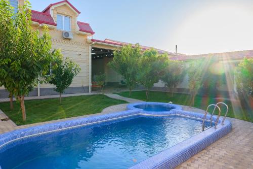 a swimming pool in the backyard of a house at Gunesh Hotel Samarkand in Khodzha-Akhrar