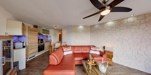 ein Wohnzimmer mit einem Sofa und einer Küche in der Unterkunft Maarberg Resort in Schalkenmehren
