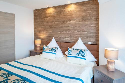 a bedroom with a bed with blue and white pillows at Maarberg Resort in Schalkenmehren