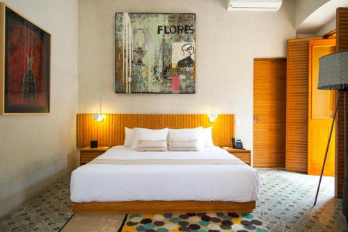 una camera con un grande letto e un dipinto sul muro di Casa Carmen Morelos a Città di Oaxaca